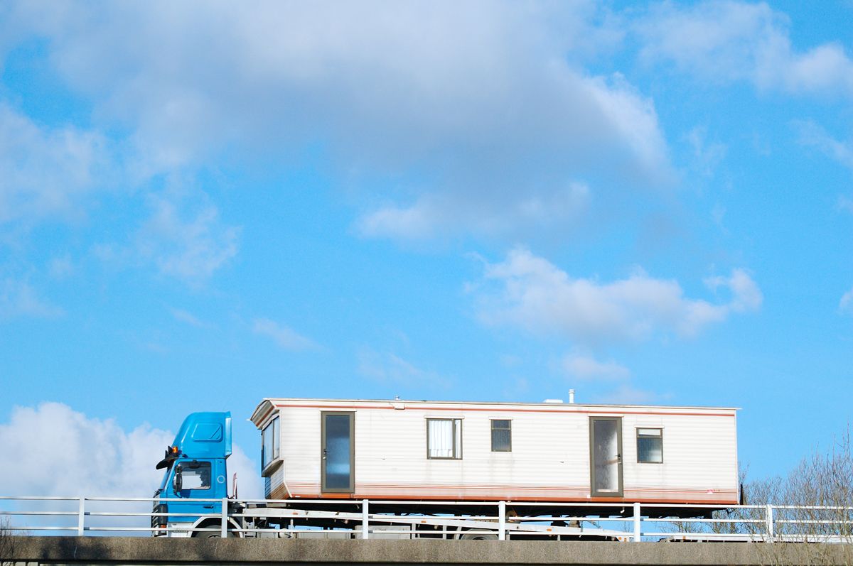 Static caravan being transported on a truck